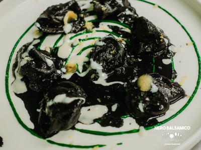 Sea bream ravioli with squid ink sauce, basil cream, Parmesan cream, and candied lemon