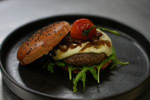 Hamburger del Nero: panino al carbone vegetale, svizzera di Angus (ca. 180 gr.), cipolla brasata all’Aceto Balsamico, fonduta di Parmigiano, rucola e pomodoro candito